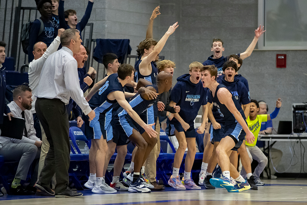 Franklin junior Sean O’Leary celebrates with teammates after hitting a crucial three-pointer late in the fourth quarter at Attleboro. (Ryan Lanigan/HockomockSports.com)